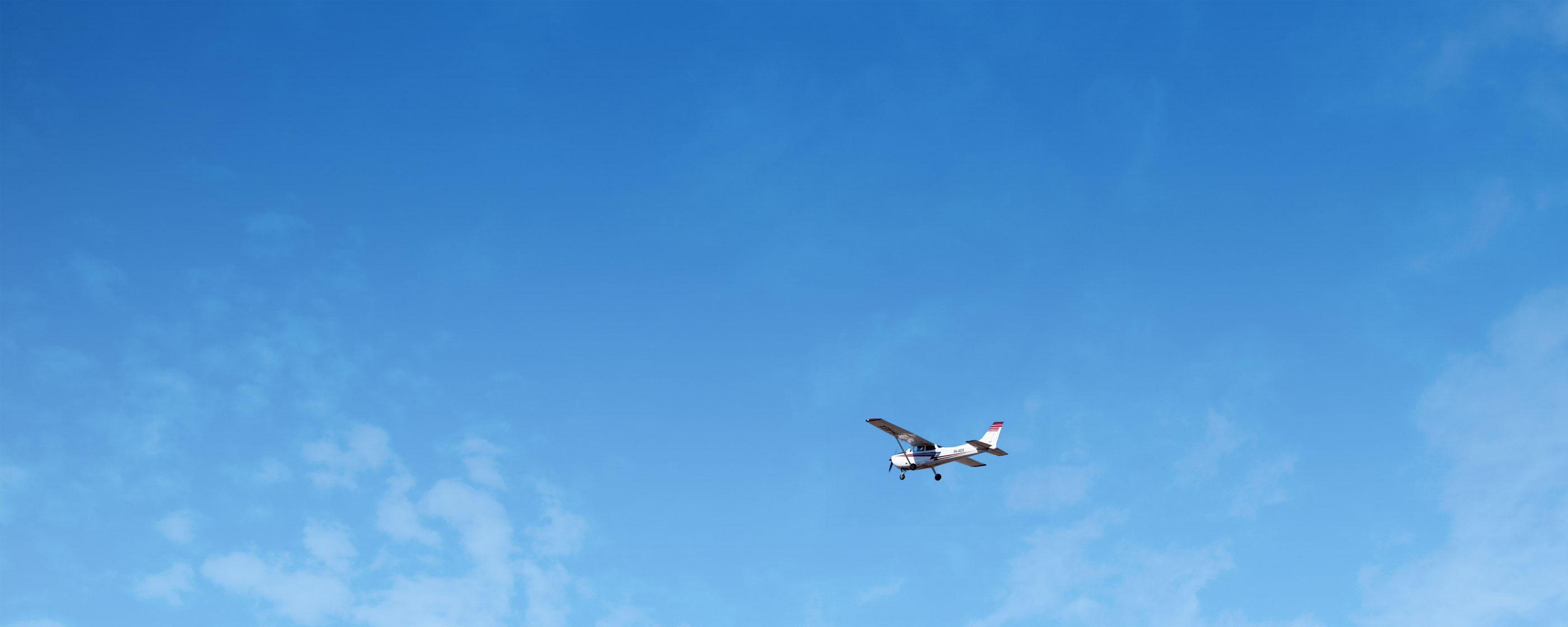 Cessna flying in a bright blue sky